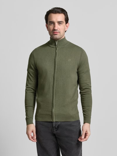 Męski model nosi Regular Fit Strickjacke aus reiner Baumwolle od Tom Tailor, oliwkowy, logo-patch, krój regular fit, golf, długie rękawy, bawełna, widok na całe ciało z przodu.