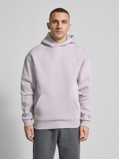 Männermodel trägt Hoodie mit Känguru-Tasche von REVIEW in Hellgrau, lockere Passform, Baumwollmischung, Nahaufnahme Oberkörper.