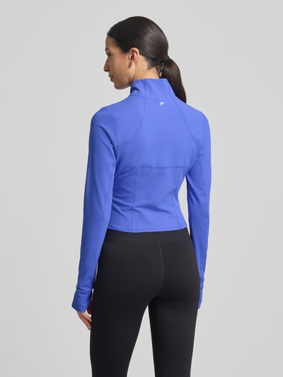 Modelka prezentuje Slim Fit Jacke mit Stehkragen Modell 'Storm' od Fabletics, kolor niebieski, krój slim fit, damka, długość pleców w rozmiarze S: 44 cm, szerokość ramion w rozmiarze S: 36 cm, szerokość klatki piersiowej w rozmiarze S: 42 cm, długość rękawa w rozmiarze S: 74 cm, z otworami na kciuki, widok całej sylwetki z tyłu