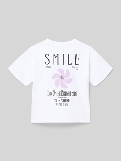 Mädchen trägt Regular Fit T-Shirt aus reiner Baumwolle Modell 'SUN-VERAS' von Only in Weiß mit Motiv-Print, Ganzkörperansicht Rückansicht.