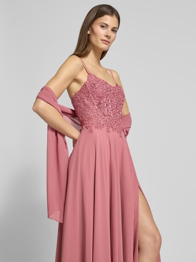 Modelka prezentuje Abendkleid mit floralem Spitznbesatz von Mascara w kolorze różowym, z cienkimi ramiączkami, ozdobne kamienie, spódnica z szyfonu, halka pod spódnicę, wszyty zamek błyskawiczny, wiązanie z tyłu, krój taliowany, dekolt carmen, szerokość w rozmiarze 36: 40 cm, długość tyłu w rozmiarze 36: 152 cm, widok z przodu, ujęcie do połowy ciała.
