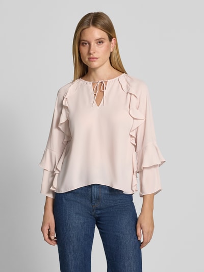 Frauenmodel trägt Regular Fit Bluse mit Schlüssellochausschnitt von monari in zartem Rosa, Rüschenbesatz, Zierschleife, 3/4-Arm, Ganzkörperansicht von vorne.
