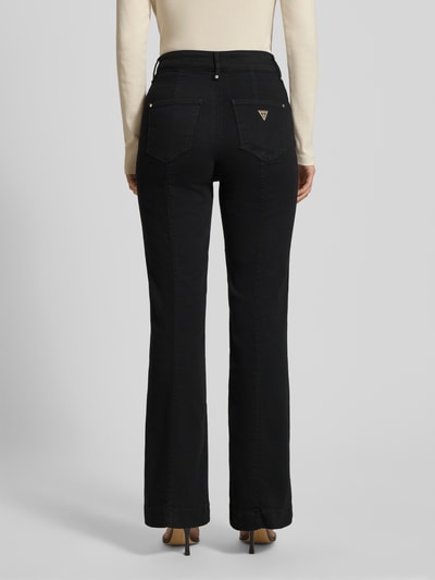Vrouwenmodel draagt Flared Jeans met Gesäßtaschen van Guess in zwart, katoen-elastaan mix, vijfzakken, band en knoopsluiting. Volledige lichaamsaanzicht achterkant.