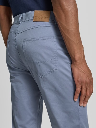 Männermodel trägt Hose mit Eingrifftaschen von Christian Berg Men aus blauem Baumwoll-Elasthan-Mix, Gesäßtaschen, Nahaufnahme Rückansicht.
