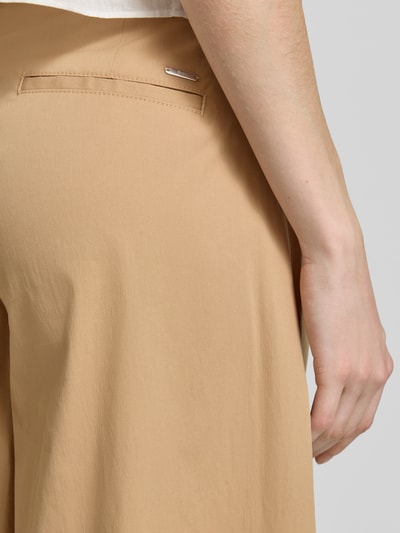 Kobiece model nosi Regular Fit Culotte aus Baumwoll-Mix Modell 'MELLI' od Brax, efekt: jednolity kolor, krój regular fit, zapięcie na guzik i zamek błyskawiczny, elastyczny pas z tunelem, wpuszczane kieszenie, kieszeń z tyłu, wykończenie materiału: popelina z mieszanki bawełny, beżowa, gładka faktura, detailaufnahme prawa strona biodra.
