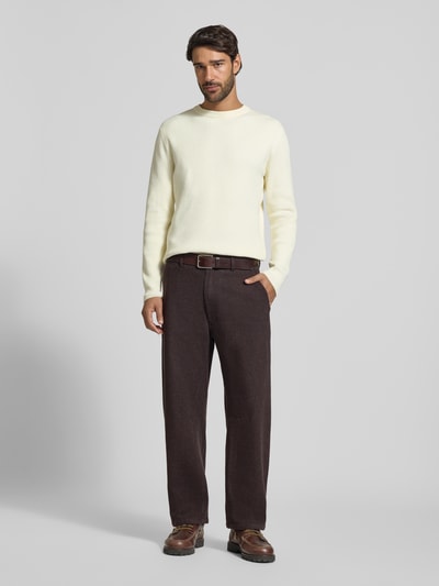 Männermodel trägt Straight Fit Stoffhose aus Baumwoll-Mix Modell 'GONAGO' von DRYKORN in Dunkelbraun, Eingrifftaschen, Ganzkörperansicht von vorne.