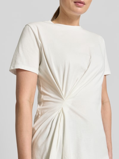 Frauenmodel trägt Regular Fit T-Shirt mit Raffungen Modell 'KIWI' von Mango aus Reine Baumwolle, Kurzärmelig, Rundhalsausschnitt, Nahaufnahme Oberkörper.