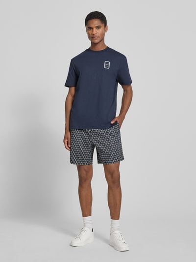 Męski model nosi Regular Fit Chinoshorts aus Baumwoll-Viskose-Mix Modell 'Aop Short Tenniscourt' von Lacoste, granatowy, gładka faktura, Herren Chinoshorts von Lacoste, Ganzkörperansicht von vorne