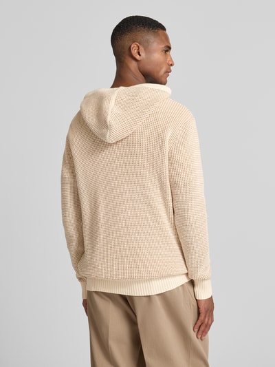 Männermodel trägt Slim Fit Hoodie mit Viskose-Anteil Modell 'Kem' von Guess in Beige mit Strick-Optik und Kapuze, Ganzkörperansicht Rückansicht. Baumwoll-Mix, elastische Abschlüsse, Rückenlänge 70 cm, Ärmellänge 64 cm.