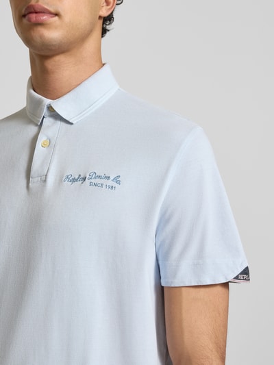 Männermodel trägt Regular Fit Poloshirt aus puur katoen van Replay met polokraag, labelstitching, korte mouw; Nahaufnahme bovenlichaam.