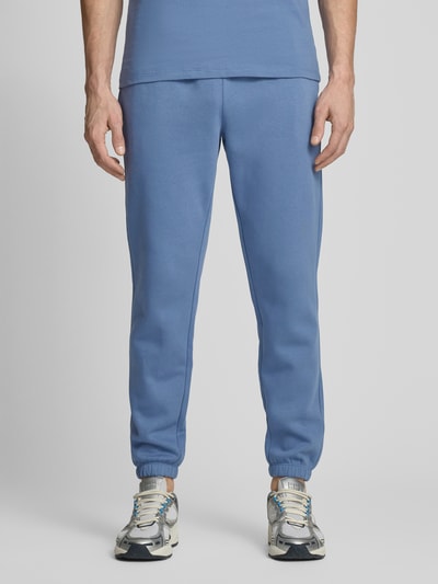 Männermodel trägt Sweatpants mit elastischem Bund von GAP in Blau, Baumwoll-Mix, Regular-Fit, Gesäßtasche, Ganzkörperansicht von vorne.