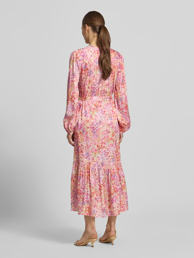 Frauenmodel trägt Midikleid aus Viskose mit Bindegürtel von Rich & Royal, rosa-lila Allover-Look, A-Linie, Rückenansicht, Ganzkörperansicht Rückansicht.