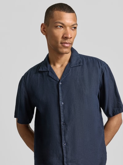 Männermodel trägt Regular Fit Leinenhemd mit Reverskragen von MCNEAL in Dunkelblau, reine Leinenstruktur, Nahaufnahme Oberkörper. Rückenlänge bei Größe M: 71 cm, Schulterbreite: 50 cm, Ärmellänge: 30 cm, Kurzärmelig, Knopfleiste.