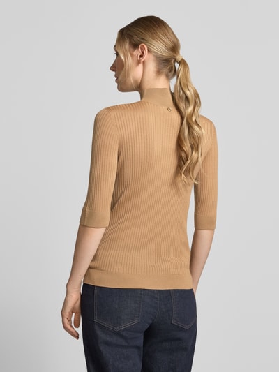Frauenmodel trägt Slim Fit Longsleeve aus reiner Lanawolle Modell 'Maglia Costine' von Liu Jo White in Beige mit Stehkragen, semitransparent, Ganzkörperansicht Rückansicht.