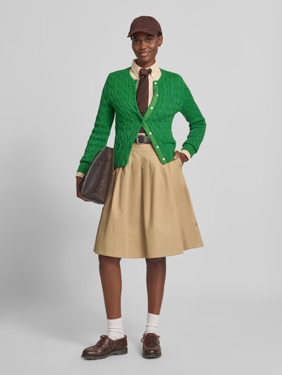 Frauenmodel trägt Regular Fit Hemdbluse aus reiner Baumwolle von Polo Ralph Lauren, kombiniert mit grünem Cardigan und beigefarbenem Rock, Ganzkörperansicht von vorne.