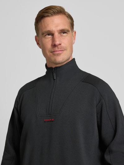 Męski model nosi Regular Fit Bluza z mieszanki bawełny Model 'ATLAS' od HUGO, efekt: jednolity kolor, nadruk z logo, troyer, dzianina dresowa, długi rękaw, mieszanka bawełny. Nahaufnahme Oberkörper.