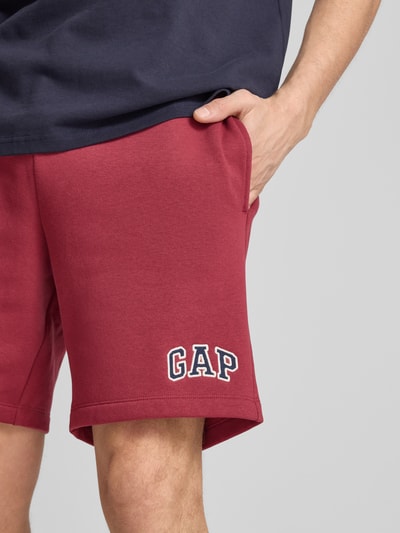 Männermodel trägt Sweatshorts mit Logo und elastischem Bund von GAP, rot, Baumwoll-Mix, Regular-Fit, Eingrifftaschen, Nahaufnahme Oberschenkel.