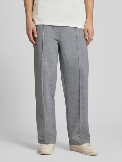 Männermodel trägt Track Pants mit Logo-Stitching Modell 'Skagen' von Pegador, Grau, Reine Baumwolle, Loose-Fit, Ganzkörperansicht von vorne.