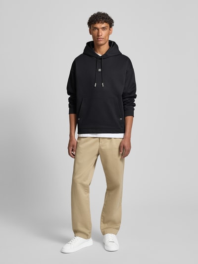 Männermodel trägt Regular Fit Hoodie aus Baumwoll-Mix Modell 'DINEO' von HUGO, Optik: Unifarben, Kängurutasche, Metall-Akzente, Ganzkörperansicht von vorne.