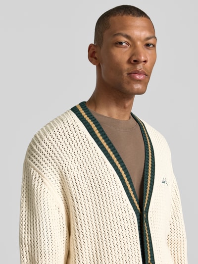 Männermodel trägt Cardigan mit Label-Stitching und aufgesetzten Taschen von Les Deux aus Reine Baumwolle, Strukturmuster, Nahaufnahme Oberkörper.
