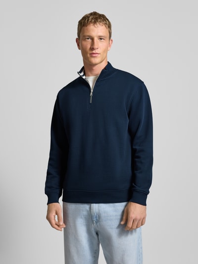 Männermodel trägt Regular Fit Troyer aus reiner Baumwolle von Marc O'Polo Denim, unifarben dunkelblau, gerippte Abschlüsse, Sweatstoff, Ganzkörperansicht von vorne.