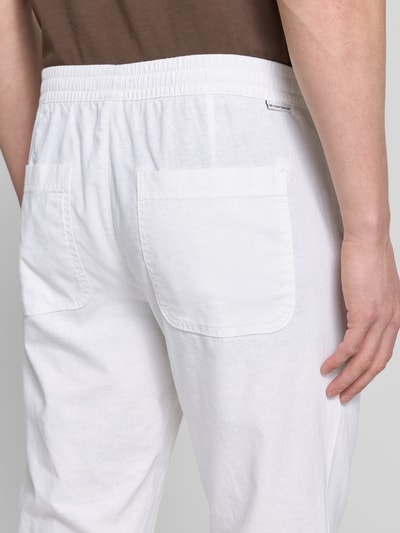 Männermodel trägt Gerade Hose aus Leinen-Baumwoll-Mix von Tom Tailor, Optik: Unifarben, Passform: Gerade, Gesäßtaschen. Detailaufnahme Rückansicht.