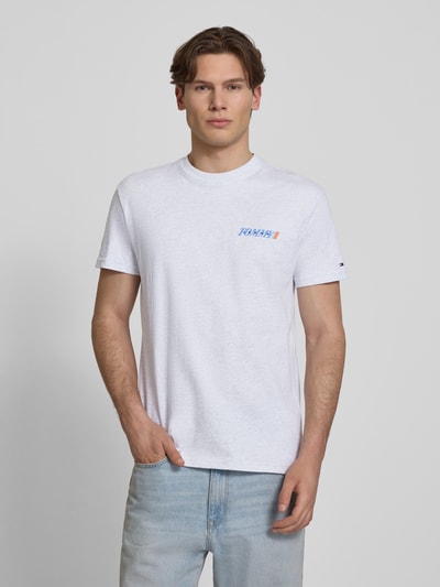 Männermodel trägt Regular Fit T-Shirt aus reiner Baumwolle von Tommy Jeans, unifarben, Label Print, kurzarm, Ganzkörperansicht von vorne