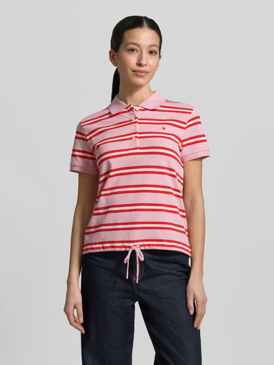 Frauenmodel trägt Regular Fit Poloshirt aus Baumwoll-Mix von Tommy Hilfiger, Optik: Unifarben, Muster: Gestreift, Logo-Detail, Kurzarm, Polokragen, Knopfleiste, Rumpfabschluss mit Tunnelzug, Materialverarbeitung: Piqué, Ganzkörperansicht von vorne.