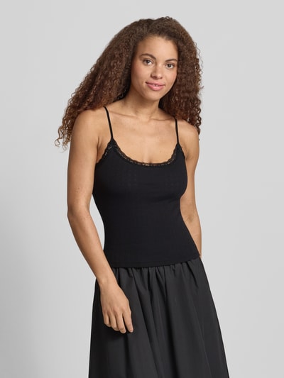 Frauenmodel trägt Slim Fit Top mit Spitzenbesatz von REVIEW, Reine Baumwolle, Spaghettiträger, Zierschleifen, schwarze Farbe, Ganzkörperansicht von vorne.