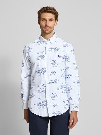 Männermodel trägt Custom Fit Freizeithemd aus reiner Baumwolle von Polo Ralph Lauren, weiß mit blauem Blumenmuster, Ganzkörperansicht von vorne.