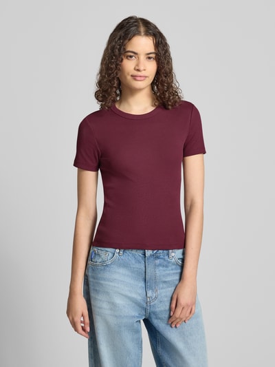 Frauenmodel trägt Regular Fit T-Shirt aus Baumwoll-Mix Modell 'VAL' von ONLY in Dunkelrot und Jeans, Damen T-Shirt, Ganzkörperansicht von vorne.