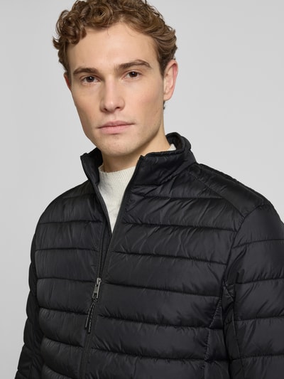 Männermodel trägt Steppjacke mit Reißverschluss von MCNEAL in Schwarz, Stehkragen, Regular Fit, Nahaufnahme Oberkörper.