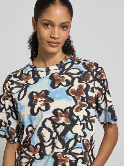 Vrouwenmodel draagt T-Shirt uit zuivere katoen van JAKE*S STUDIO WOMAN, losse fit, ronde hals, half lange mouw, bloemenpatroon, close-up bovenlichaam.