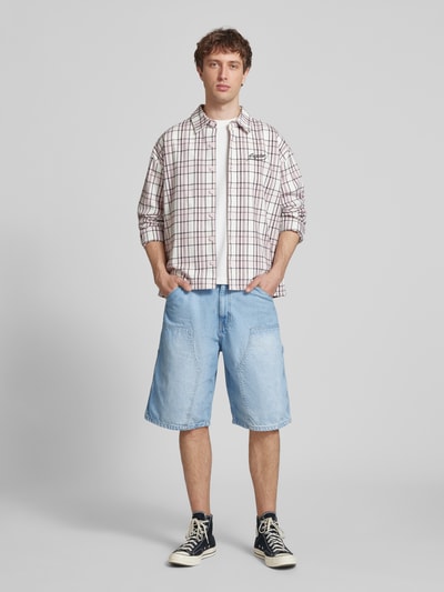 Männermodel trägt Regular Fit Jeansshorts mit Label-Details von REVIEW aus Reine Baumwolle im 5-Pocket-Design, hellblau, Ganzkörperansicht von vorne.