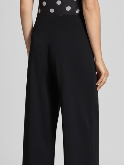 Frauenmodel trägt Weite Hose aus reiner Viskose Modell 'BREMEN' von ONLY in Schwarz, glatte Textur, Ganzkörperansicht Rückansicht, Damen Weite Hose von ONLY.