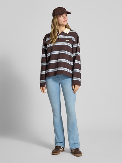 Frauenmodel trägt Flared Fit Jeans im 5-Pocket-Design von Review aus elastischem Baumwoll-Mix, helle Waschung, Ganzkörperansicht von vorne.