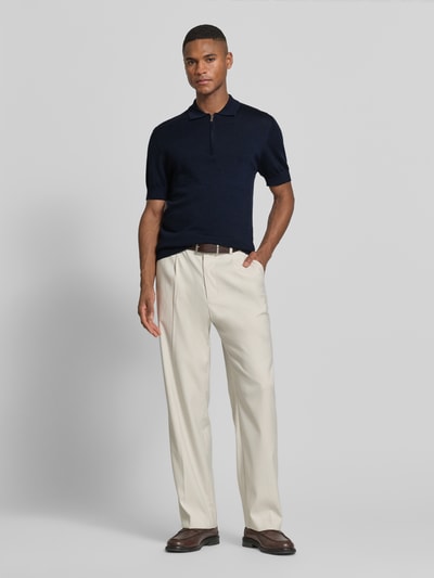 Männermodel trägt Slim Fit Poloshirt aus reiner Wolle von Matinique in Dunkelblau, Strick-Optik, Polo-Kragen, Ganzkörperansicht von vorne.