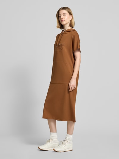 Frauenmodel trägt Sweatkleid mit Kapuze von Soyaconcept in Braun, Material-Mix mit Modal-Anteil, Gerader-Schnitt, Kapuze, Label-Print, Midikleid, Ganzkörperansicht von vorne.