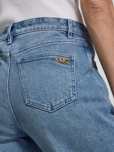 Frauenmodel trägt Flared Fit Jeans mit aufgesetzten Taschen von MICHAEL Michael Kors aus elastischem Baumwoll-Mix in mittlerem Blau, Nahaufnahme Rückansicht.