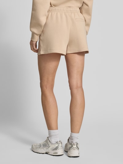 Kobiece modelka nosi Regular Fit Sweatshorts aus Baumwoll-Mix od Lacoste, efekt: jednolity kolor, mieszanka bawełny, wyhaftowane logo, tunel, elastyczny ściągacz, wpuszczane kieszenie z przodu, kieszeń z tyłu, dzianina dresowa, Ganzkörperansicht Rückansicht.