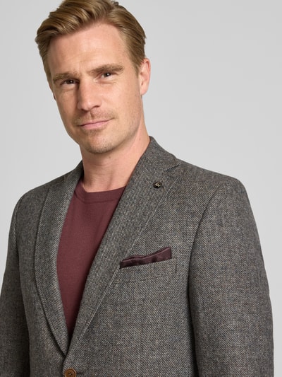 Männermodel trägt Slim Fit Sakko mit Viskose-Anteil Modell 'Theo' von Carl Gross, dezente Grautöne, strukturierte Oberfläche, Nahaufnahme Oberkörper.
