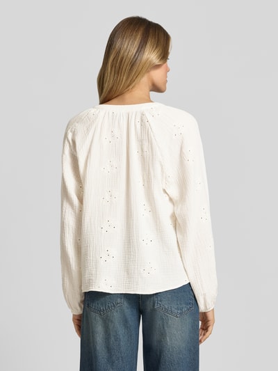 Frauenmodel trägt Relaxed Fit Langarmbluse aus reiner Baumwolle Modell 'NATALI' von Vero Moda in Unifarbe mit Lochstickerei, Seersucker-Textur, elastische Ärmelabschlüsse, Ballonärmel, Ganzkörperansicht Rückansicht.
