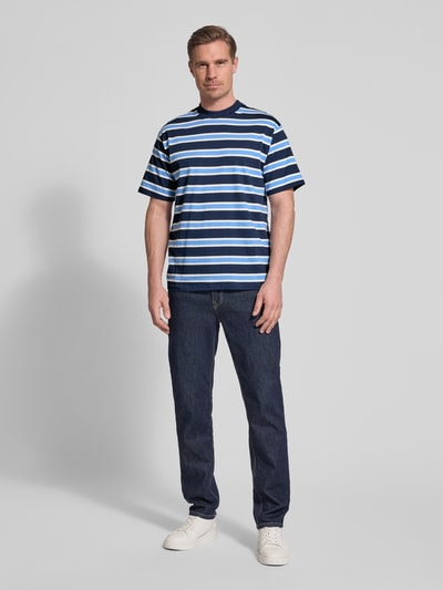 Männermodel trägt Regular Fit T-Shirt mit Rundhalsausschnitt von Casual Friday, reine Baumwolle, dunkelblau gestreift, kurzärmelig, Ganzkörperansicht von vorne.