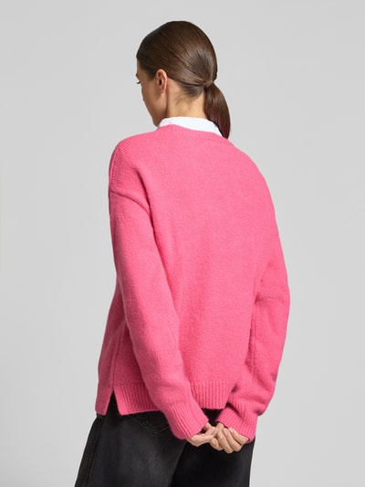 Vrouwenmodel draagt Oversized Fit Strickpullover mit Rundhalsausschnitt van Milano Italy in felroze, geribde boorden, elastische mix, strick-look, langemouwen, detail op rug, rugaanzicht.