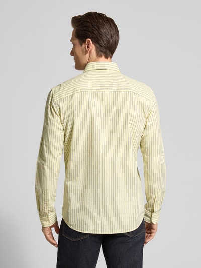 Männermodel trägt Slim Fit Freizeithemd aus reiner Baumwolle von MCNEAL in Gelb mit feinen Streifen, Hemdkragen, Rückenansicht, Ganzkörperansicht.