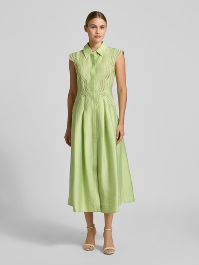 Frauenmodel trägt Hemdblusenkleid aus Modal-Mix mit Spitze Modell 'COLE' von Copenhagen Muse in zartem Grün, A-Linie, Midikleid, verdeckte Knopfleiste, glatte Textur, Ganzkörperansicht von vorne. Rückenlänge bei Größe S: 128 cm, Brustweite bei Größe S: 41 cm.