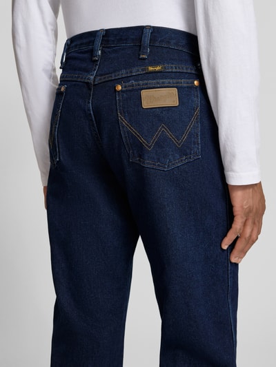 Männermodel trägt Cowboy Cut Jeans im 5-Pocket-Design von Wrangler in Dunkelblau, Reine Baumwolle, Gerader-Schnitt, Nahaufnahme Rückansicht.