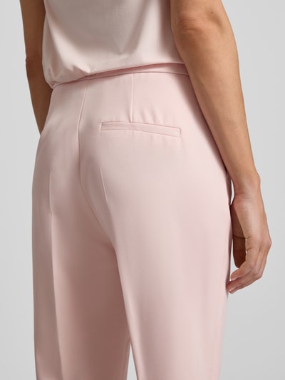 Frauenmodel trägt Slim Fit Schmale Hose mit elastischem Bund von s.Oliver BLACK LABEL, Optik: Unifarben, angedeutete Gesäßtaschen, Detailaufnahme Rückansicht.