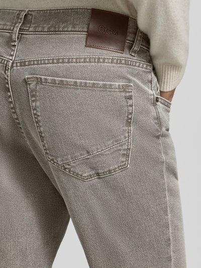 Männermodel trägt Slim Fit Jeans mit 5-Pocket-Design Modell 'Chuck' von Brax im Baumwoll-Elasthan-Mix, Detailaufnahme Rückansicht. Bundweite bei Größe 32/32: 42 cm, Innenbeinlänge: 79 cm, angesagte Waschung, sichtbarer Lederpatch.