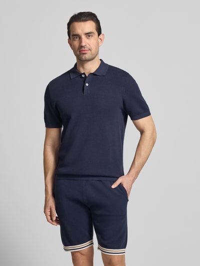 Męski model nosi Koszulka polo Slim Fit z fakturowanym wzorem Model 'Johan' od Christian Berg Men z bawełny, krój slim fit, kołnierzyk polo, krótkie rękawy, długość tyłu 74 cm, długość rękawów 24 cm, granatowy jednokolorowy, widok całej sylwetki z przodu.